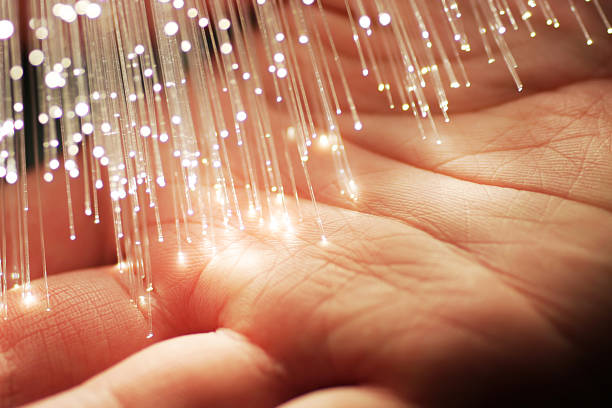 Fiber Optics & Hand Fiber optics spreading light on a human hand. palm fiber stock pictures, royalty-free photos & images