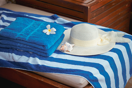 Hat and flowers on a beach towel
