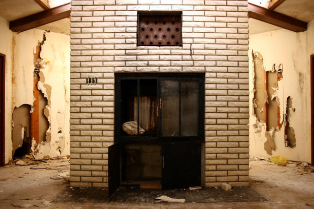 White fireplace in center of octagonal room "A 70's future home didn't make it quite too far into the future. Central fireplace, framed by busted sheetrock walls and natural lighting from above.. I've more" drywall fireplace stock pictures, royalty-free photos & images