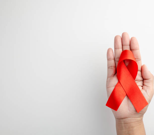 istock AIDS ribbon in hand isolated on white background 1727358086