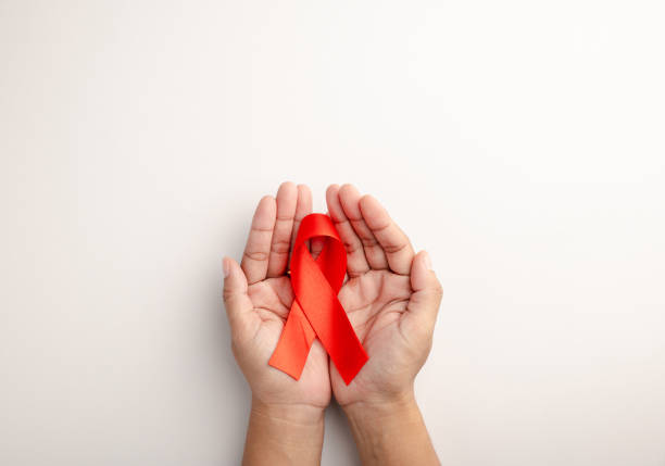istock AIDS ribbon in hand isolated on white background 1727358090