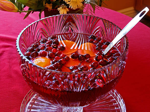 Fruit Punch Bowl A colorful fruit punch in a crystal glass bowl with cranberries and oranges. punch drink stock pictures, royalty-free photos & images
