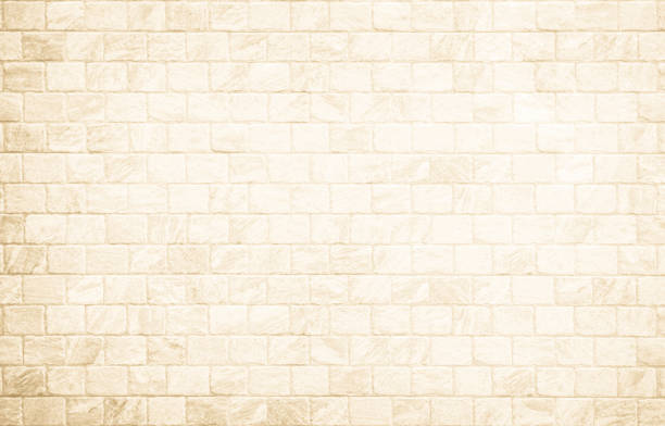 istock Empty background of wide cream brick wall texture. Beige old brown brick wall concrete or stone textured, wallpaper limestone abstract flooring. Grid uneven interior rock. Home decor design backdrop. 1727380314