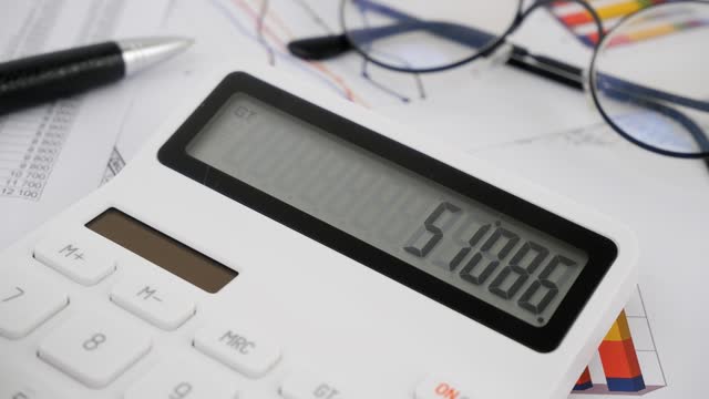Businessman using white calculator for counting money close up.
