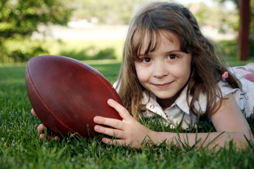Young girl playing with ball.