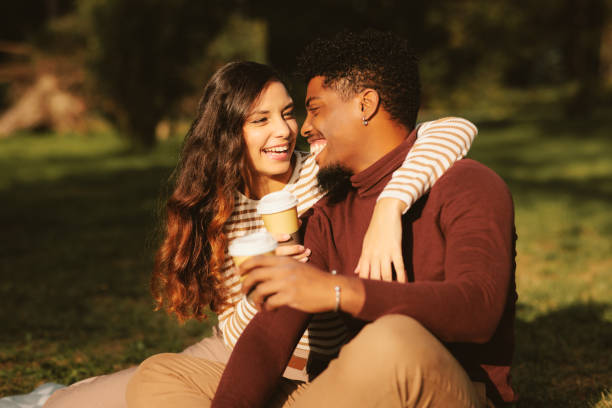 istock Young couple enjoying a park on a sunny day and drinking coffee 1727387654