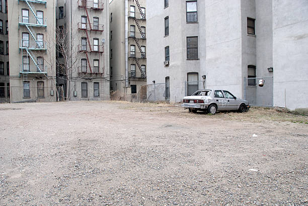 Demolished car "Broken windows of an old demolished car between grey housing in Harlem, New York City." harlem park stock pictures, royalty-free photos & images