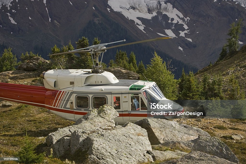 Mountain top landing Helicopter landed in the mountains surrounded by rocks and trees. Bugaboo Mountains Stock Photo