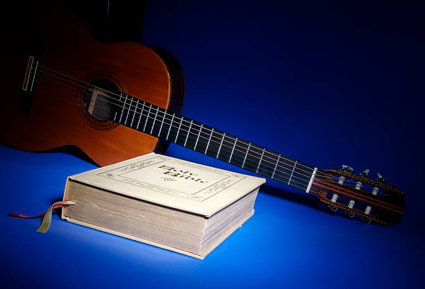 Bible and Music Series Warm guitar and family Bible typify Christian music on blue background psaltery stock pictures, royalty-free photos & images