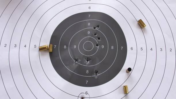 istock Bullet-Riddled Paper Shooting Target with Spent Shell Casings Close-Up 1727419989
