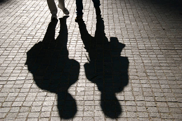 istock Pair of Shadows Walk on Dark Cobblestone Street 172742194