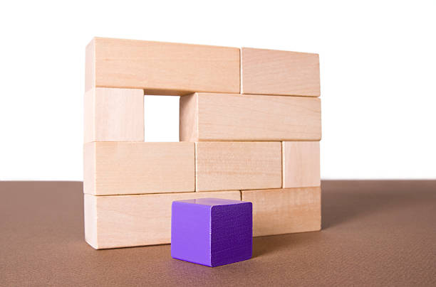 istock Purple cube in front of a toy block wall 172742748