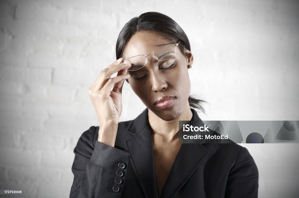 Business Woman Headache Business Woman with hand on temple from a rough day at work or an illness. Stressed and fatigued with hand on her temple. Time: After 5.. the light stream in through the blinds casting a pattern on the back wall. 30-39 Years Stock Photo