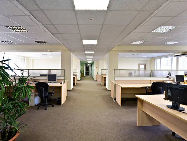 Office aisle with cubicles and tables