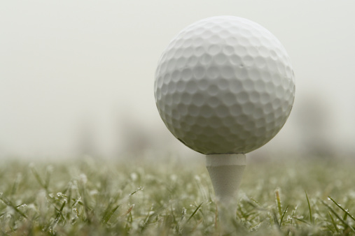 Golf ball on tee and some frost.