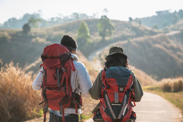 Travelers hiking with backpack traveling in forest wild and look around and explore while walking in nature wood. happy holiday vacation trip.