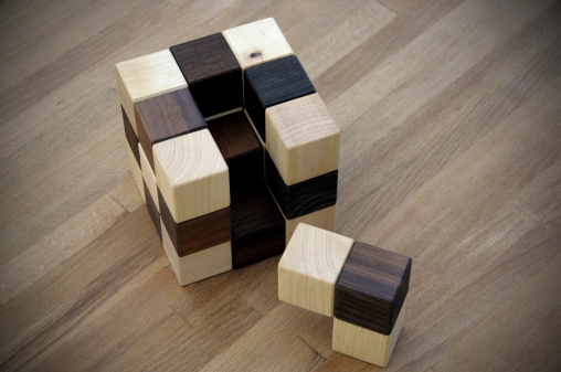 wooden cube on wooden table. vignetting is intended.