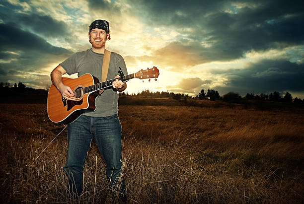 istock Young Musician With Guitar At Sunset in Field 172745321