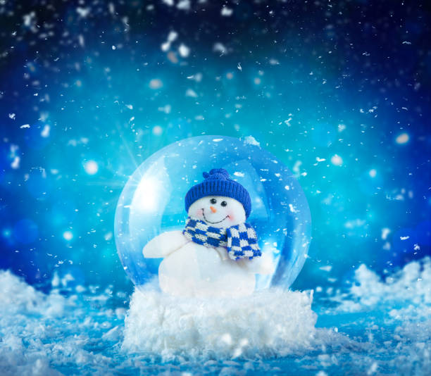 Glass snow globe with snowman on blue Christmas background.