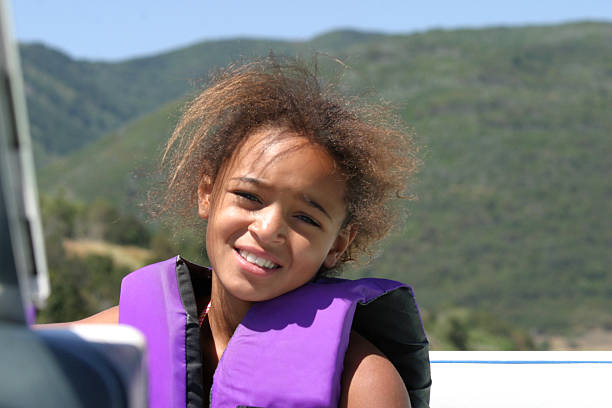 jovem garota em barco - life jacket child black sailing - fotografias e filmes do acervo