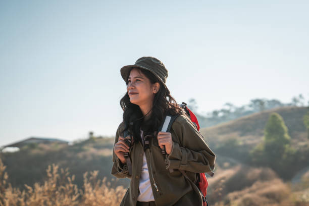 Travelers hiking with backpack traveling in forest wild and look around and explore while walking in nature wood. happy holiday vacation trip.