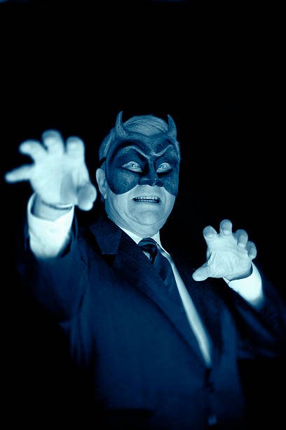 The Big Boss Toned portrait of a senior businessman with a devil mask on. autocratic leadership stock pictures, royalty-free photos & images