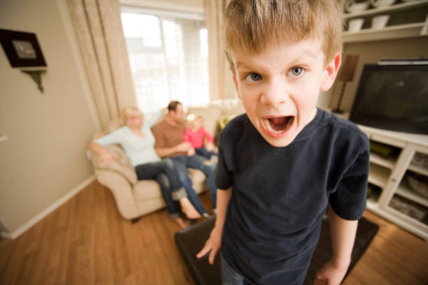Spoiled child screaming at living room stock photo