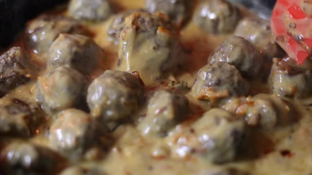 Delicious homemade meatballs with creamy sauce in saucepan