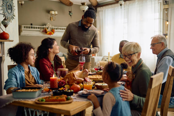 istock Happy multiracial extended family on Thanksgiving at dining table. 1727471296
