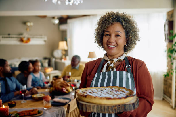 istock Happy mature woman with Thanksgiving pie looking at camera. 1727475672
