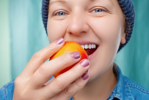 Closeup image of a young woman holding oranges in hands