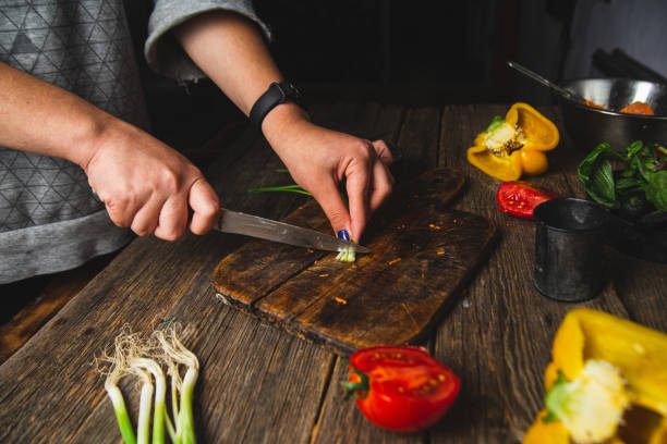 istock Girl cutting vegetables on a wooden board 1727477435
