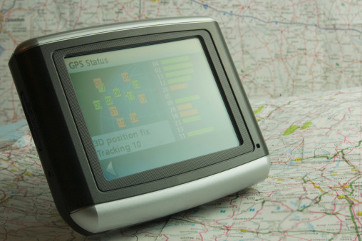 This is a picture of a GPS unit with paper map background