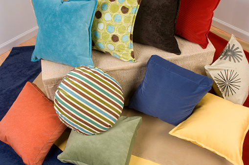 A collection of colorful throw pillows in a variety of colors, shapes and fabrics.