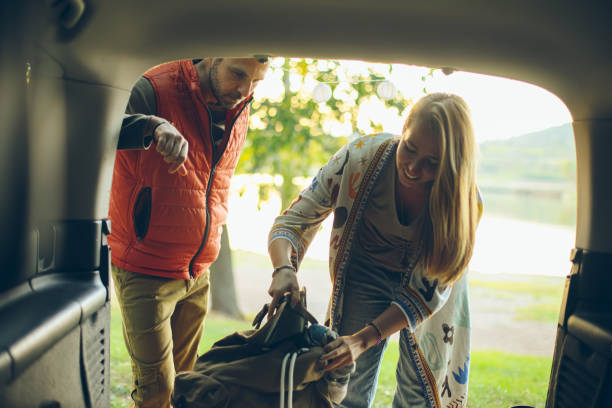 istock Young handsome couple packing their backpack on a road trip at the lake 1727494480