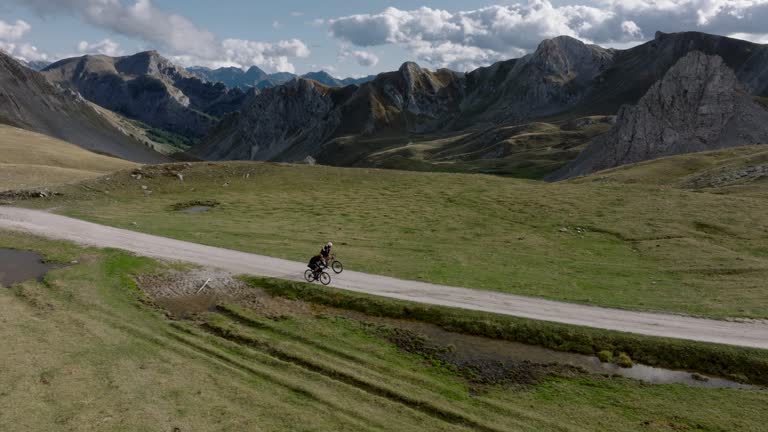 Aerial drone view of cyclists climbing high mountain pass