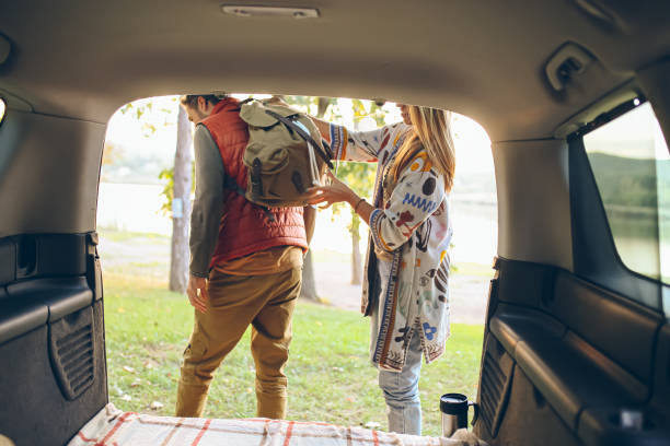 istock Young handsome couple packing their backpack on a road trip at the lake 1727496682