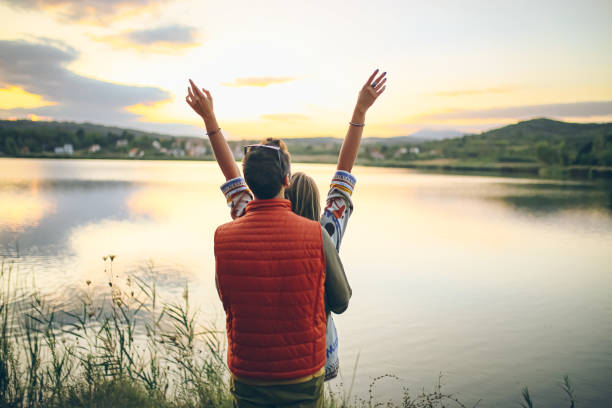 Young couple embracing at the lake in sunset