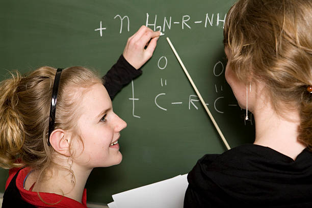 istock Young girl is learning chemistry, teacher helps 172750608