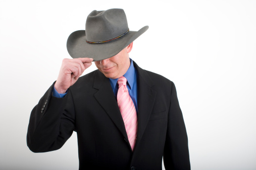 Studio shot of a man in business suit wearing a cowboy hat his eyes are hiddenPlease see similar images in my portfolio: