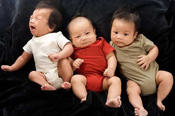 Three adorable babies who are all two months old on a black blanket. They all have various reactions to getting their photos taken !  Two are twins and one is their first cousin all born within a week of each other.  They could easily model triplets. Please see some similar pictures from my portfolio: