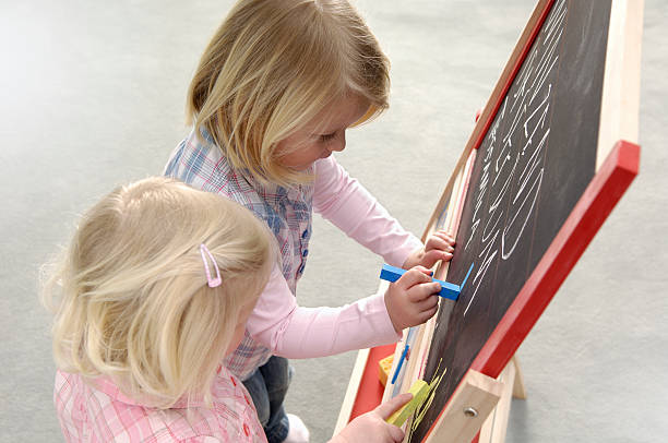 istock Two little girls writing on a chalkboard 172751151