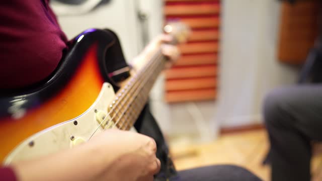 Close-up of a man playing electric guitar indoors