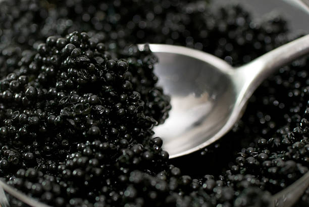 Spoon in Caviar spoon in a bowl of caviar; close up fish roe stock pictures, royalty-free photos & images