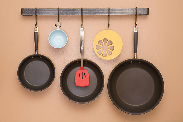 Pans and Utensils Hanging on Kitchen Wall stock photo