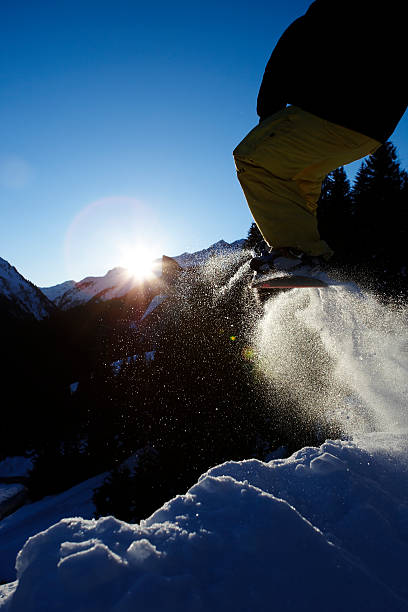 snowboarder against the light-taking off stock photo