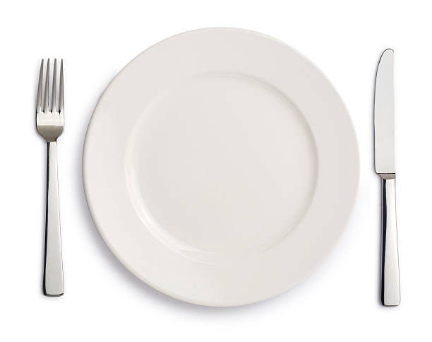 Dinner white plate , knife and fork on white background stock photo