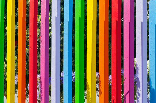 Multicolored painted concrete fence  surrounding a children playground, close-up full frame front view.