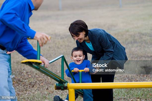 Baby Boy On Seesaw With Parents Stock Photo - Download Image Now - Adult, Assistance, Autumn
