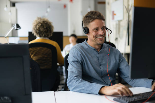 istock Happy male customer service representative working on PC in call center. 1727530968